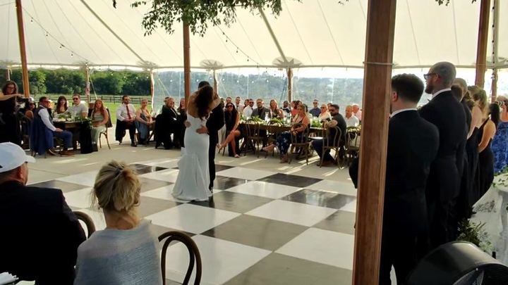 A couple dancing alone on the black and white floor at Seneca Ridge while their guests watch from the tables